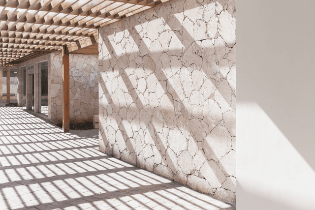 Shaded outdoor walkway with timber pergola and stone wall