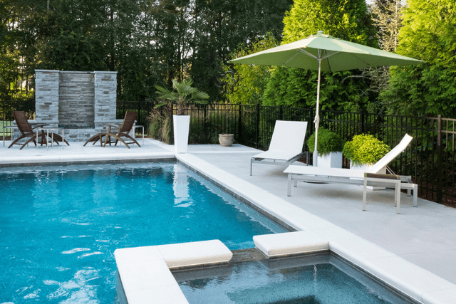 Modern pool with clean deck lines and shaded loungers