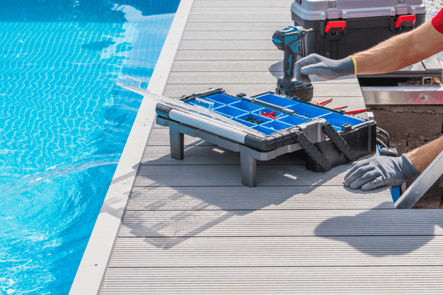 Poolside deck work with tools and fixings laid out